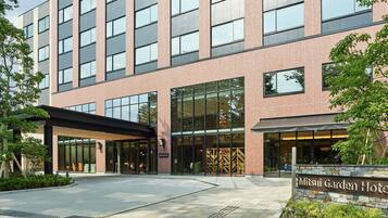 A modern hotel with a brick facade, large windows, and a covered entrance area.