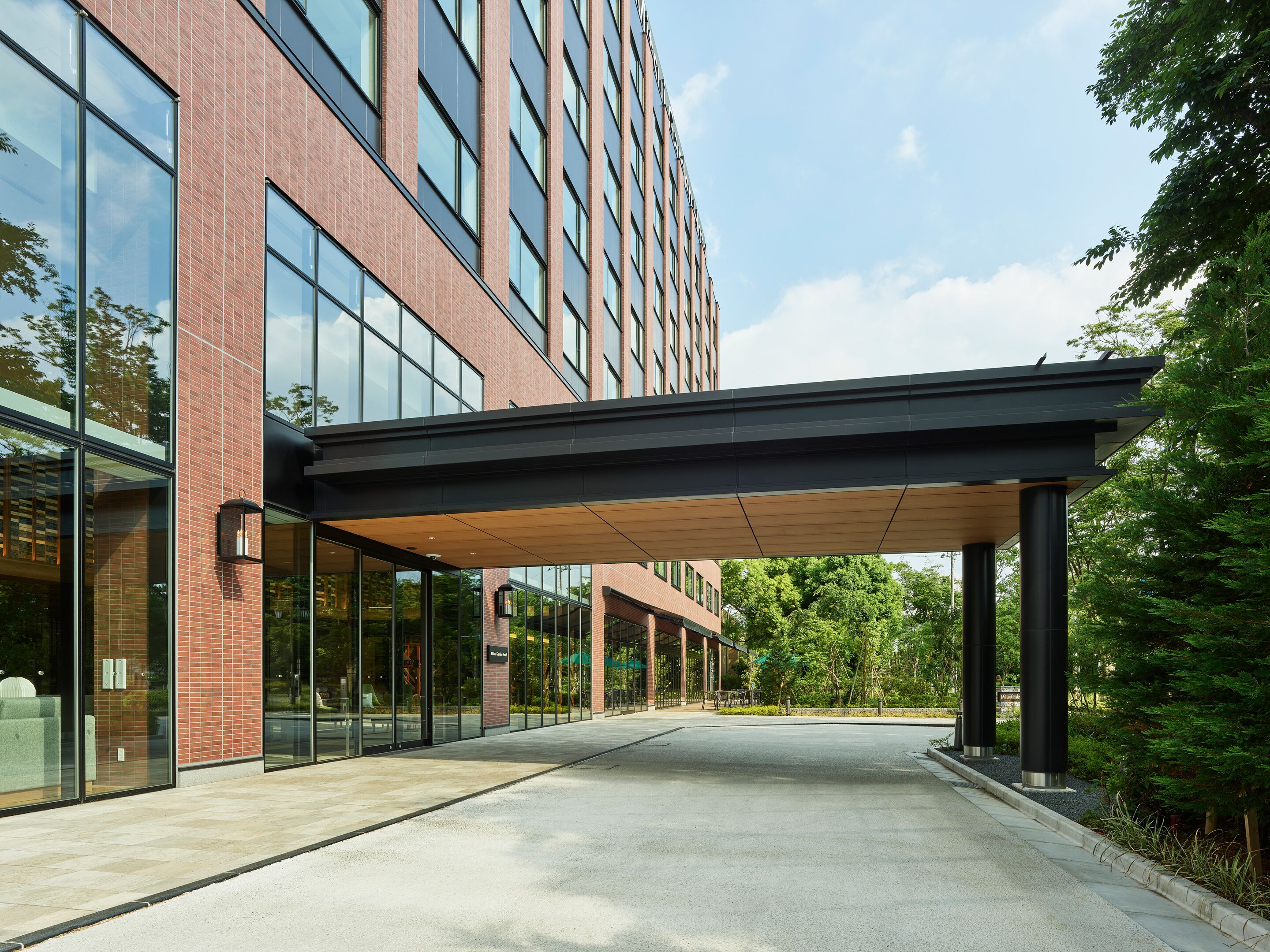 A modern building with large windows and a covered walkway.