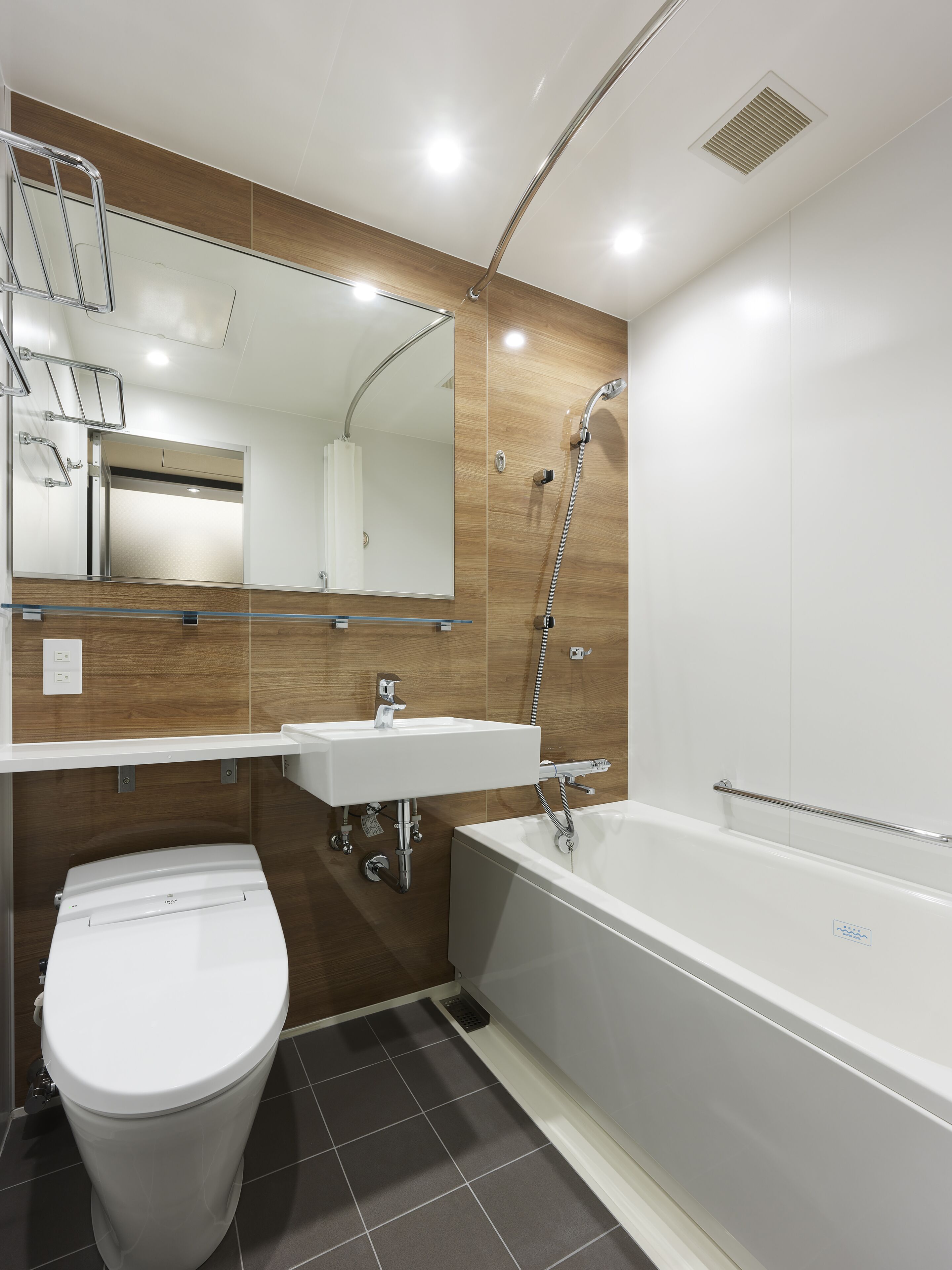 Een moderne badkamer met toilet, wastafel en bad.