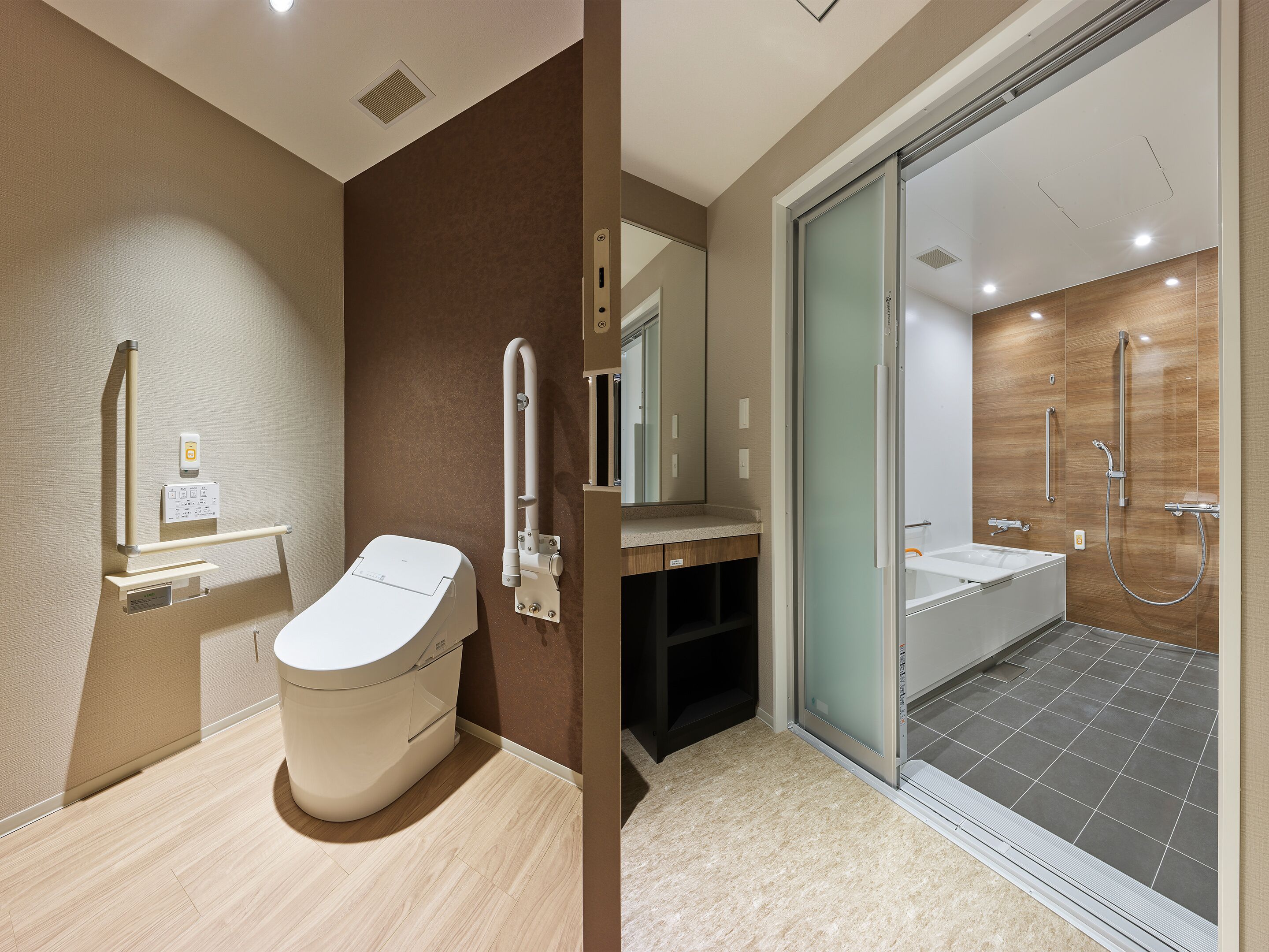Ein modernes Badezimmer mit Toilette, Waschtisch mit Spiegel und Duschbereich.