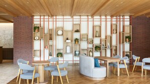 A modern interior with wooden floors, a central seating area with a round table, and built-in shelving with various items. - Mitsui Garden Hotel Kashiwanoha Park Side Chiba  (Kashiwa)