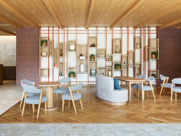 Un intérieur moderne avec des planchers en bois, un espace salon central doté d’une table ronde et des étagères intégrées où sont exposés divers objets.