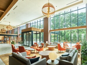 Un amplio espacio interior con grandes ventanales, muebles modernos y una zona de estar central.