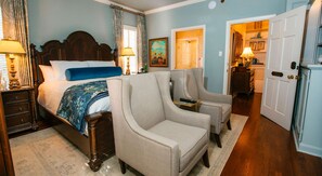 A bedroom with a bed, two armchairs, a nightstand, and a dresser. - The Reserve at Hot Springs (Hot Springs)