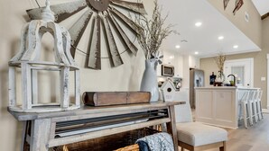 A rustic interior with a large wall-mounted windmill, wicker baskets, and a wooden bench. - Farmhouse Charm - Waco/Magnolia/Baylor (Waco)