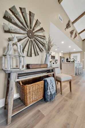 Experience the perfect blend of rustic charm and modern convenience in this inviting kitchen, featuring a unique metal art piece, a cozy dining area, and a kitchen island with appliances.