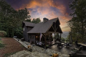 A log cabin with a deck, outdoor seating, and a scenic mountain view. - Breathtaking Blue Ridge Mountain Views and Sunset, Sleeps 8! (Cherry Log)