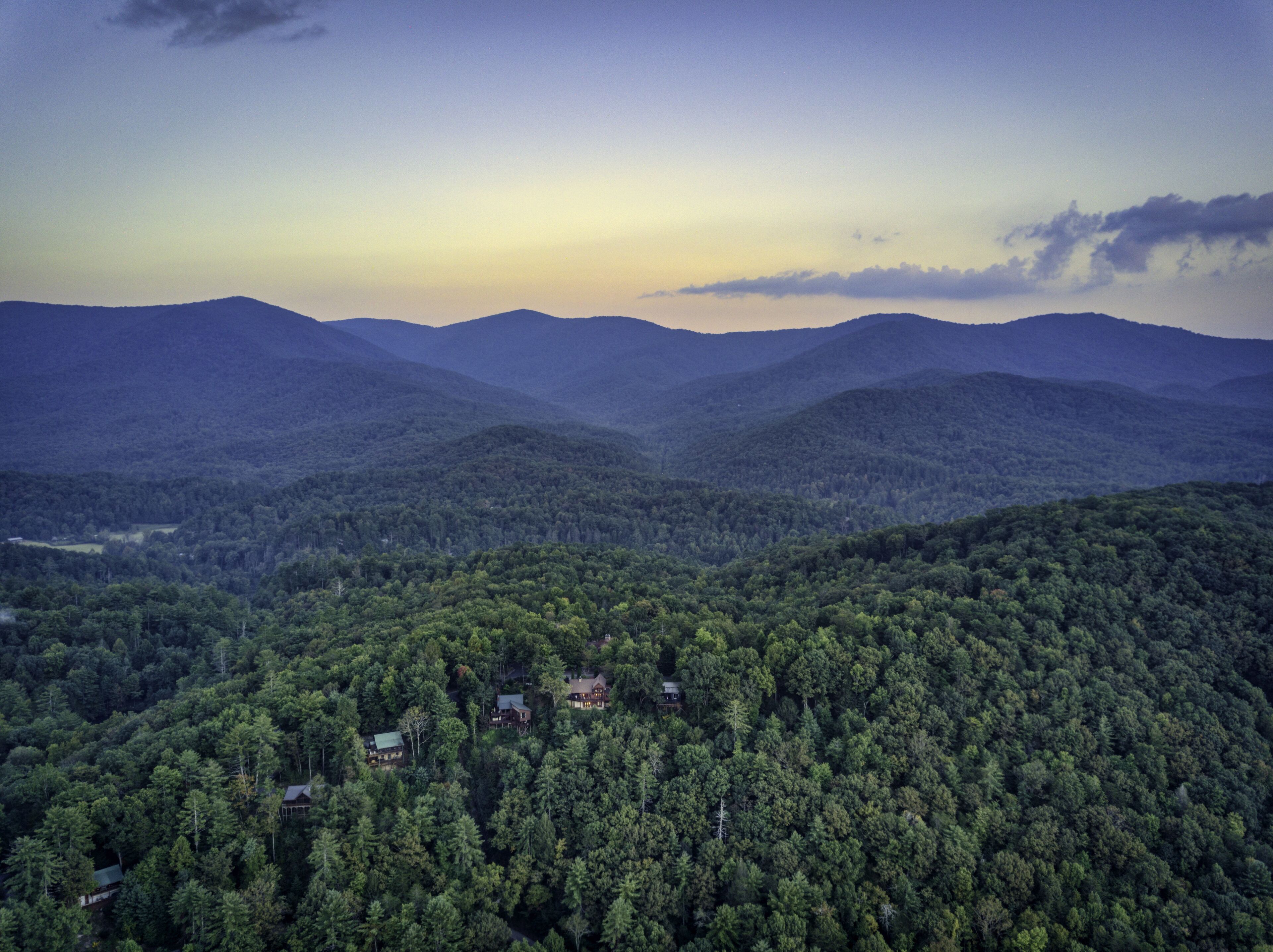 A forested mountain landscape with several cabins.