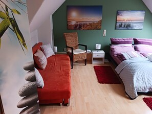 Une chambre à coucher comprenant un lit, une chaise, une table de chevet et une lampe fixée au mur.