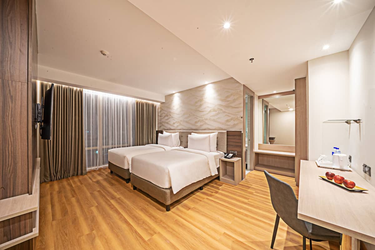 Een hotelkamer met een groot bed, een bureau met stoel en een eettafel met appels.