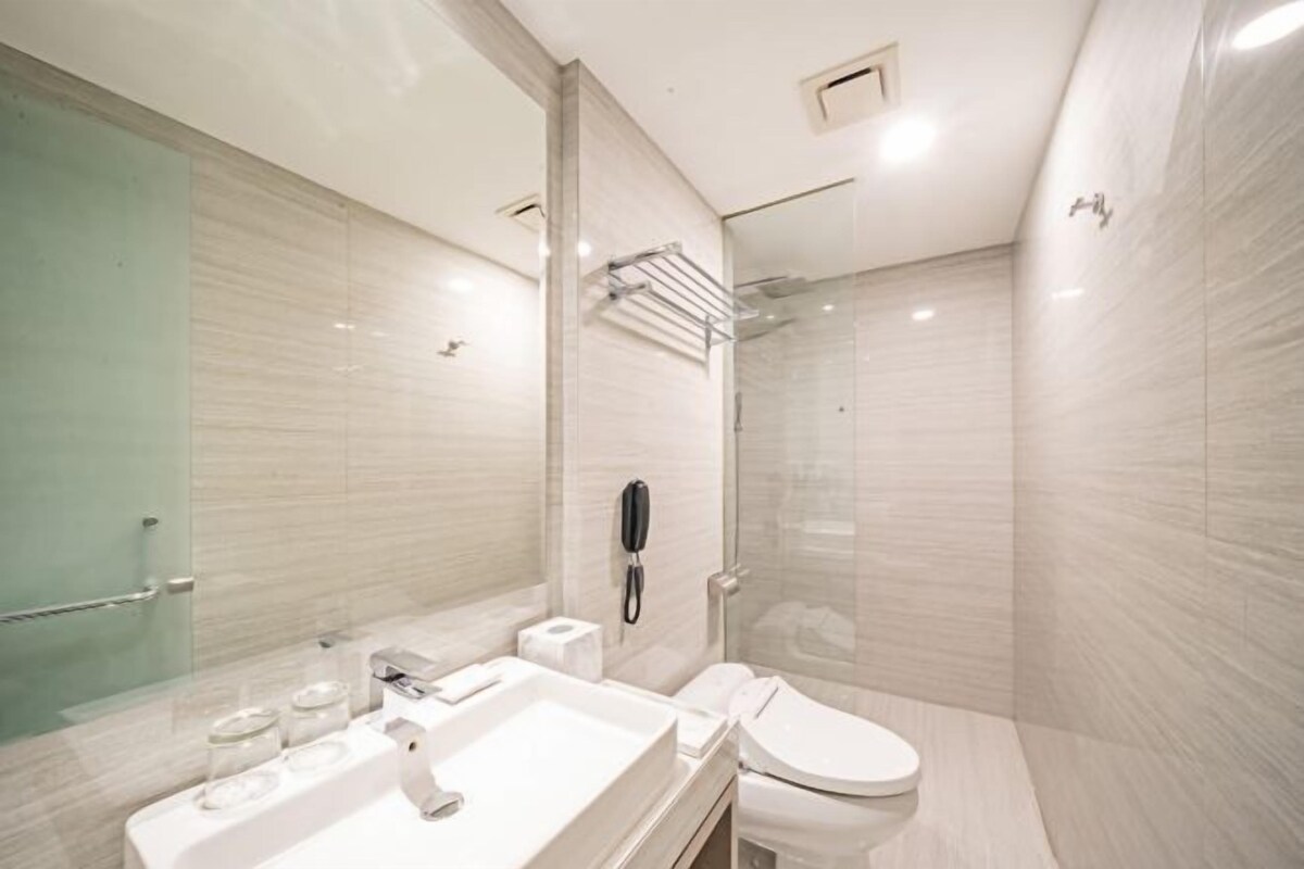 Et moderne badeværelse med vask, toilet og brusebad.
