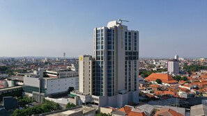 Un hotel moderno de gran altura con múltiples pisos, amplias ventanas y un llamativo letrero que dice 'Hotel'.