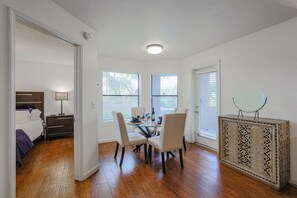 A room with a bed, bedside table, lamp, and a dining area with chairs and a table. - Scottsdale ground floor golf course condo (Scottsdale)