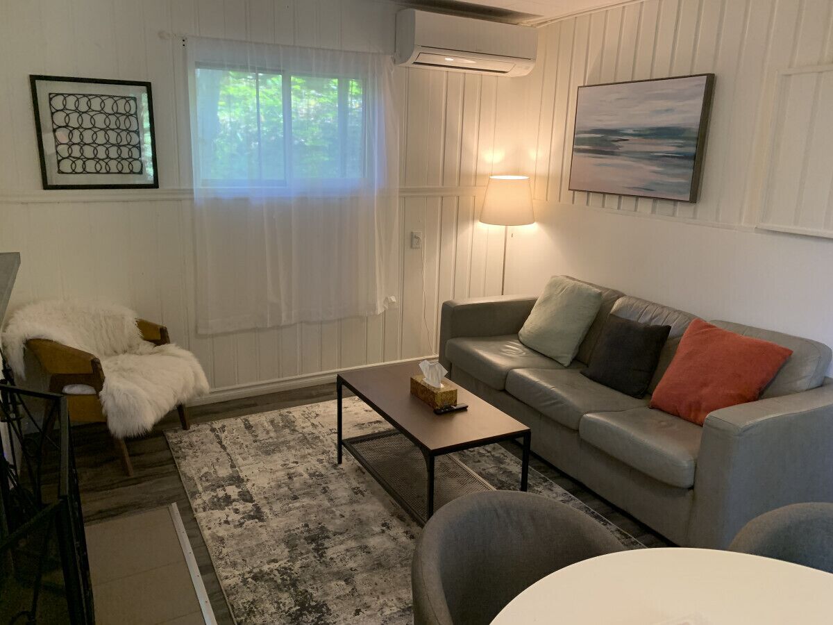 A living room with a sofa, a coffee table, a chair, and a lamp.