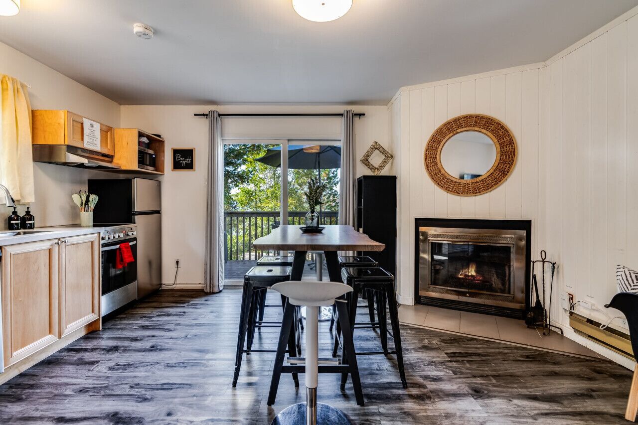 Een moderne keuken met een eetgedeelte, een open haard en uitzicht op de omgeving.