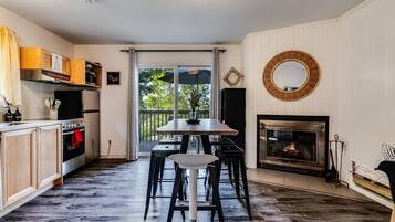 Een moderne keuken met een eetgedeelte, een open haard en uitzicht op de omgeving.