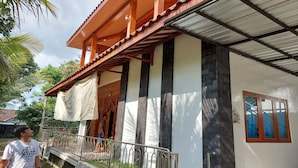 Ein Gebäude mit einer Holzveranda, einem Metallgeländer und einer Treppe zum Eingang.