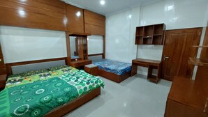 Ein Schlafzimmer mit Bett, Schreibtisch und Kleiderschrank.