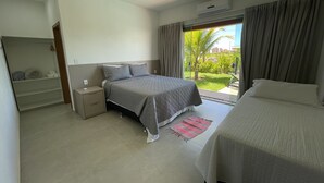 A bedroom with a bed, a nightstand, a wardrobe, and a view of a garden through a window. - Casa COMPLETA com Piscina 1 Min da Praia (Prado)