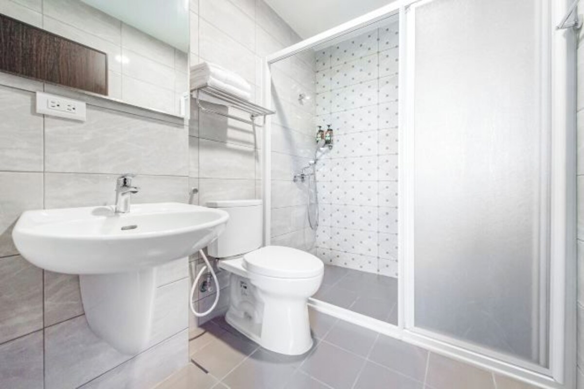 A modern bathroom with a sink, toilet, and glass-enclosed shower.