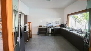 Une cuisine de taille réduite équipée d’un réfrigérateur, d’une cuisinière et d’un évier.