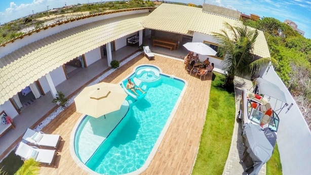 Une piscine avec un toboggan, des chaises longues et un espace de détente abrité.