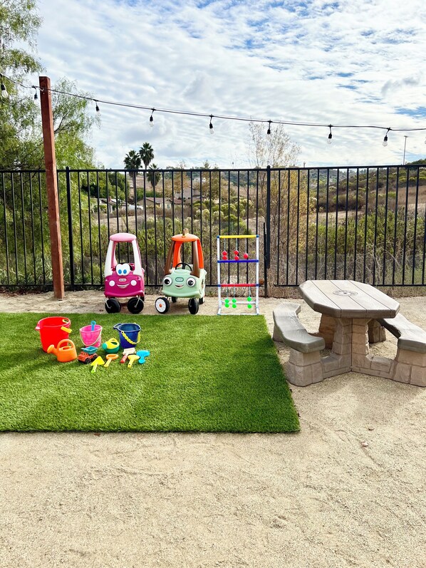 A children's play area with a picnic table and toys.