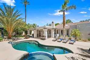 A pool area with lounge chairs and a covered patio.
