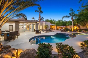 A modern house with a swimming pool, outdoor seating, and a patio area. - Rancho Mirage Estate | Saltwater Pool, Spa, Game Room, Outdoor Kitchen · 4BR (Rancho Mirage)