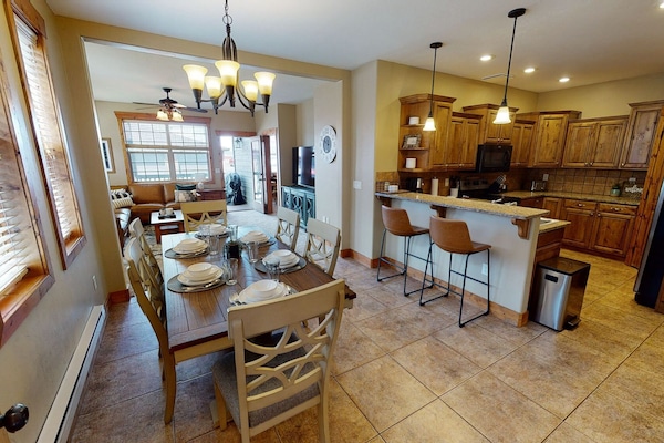 Entryway view of dining area, kitchen, and living room in the background.