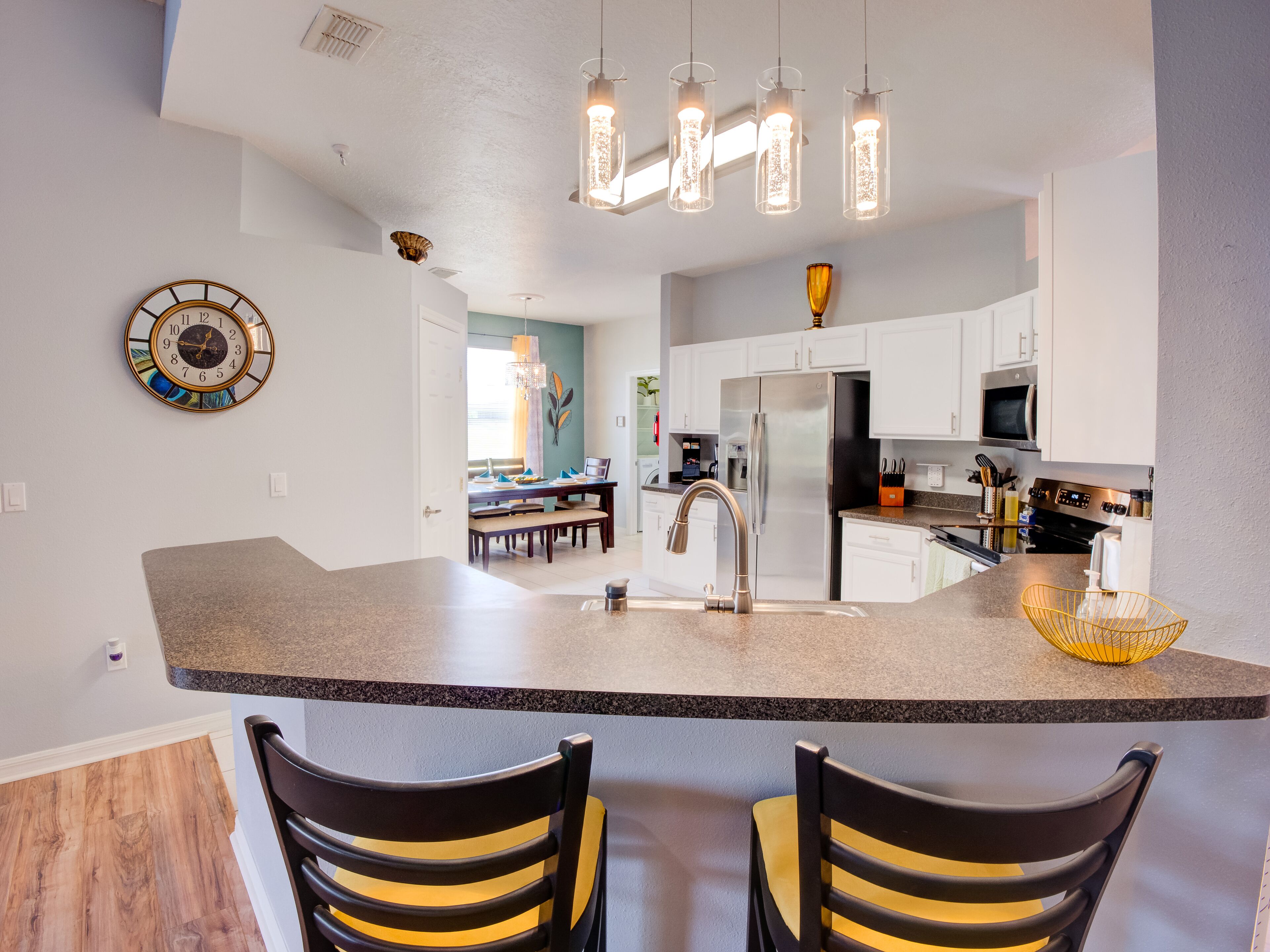 A modern kitchen with a central island, stainless steel appliances, and pendant lighting.