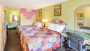 Una habitación de hotel con dos camas, un escritorio con silla, un espejo y una cómoda.