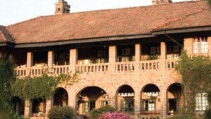 Un edificio grande y de estilo histórico con tejado de baldosas y múltiples arcos.