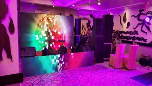 A room with a disco ball, a DJ booth, and a patterned carpet. - Hotel Comfort Inn Bl (Bareilly)