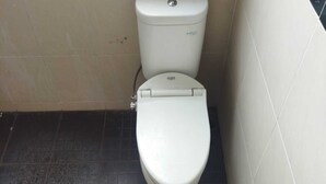 A toilet with a closed lid and a flush handle. - Griya Joglo Kaliurang (Ngaglik)