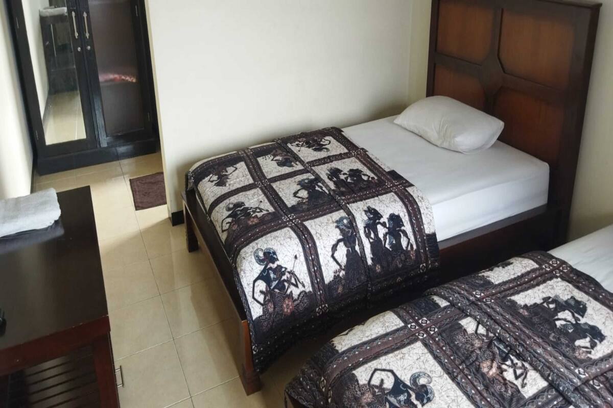 Una habitación de hotel con una cama, una mesita de noche y un espejo.