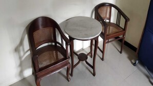 A small room with a round table and two wooden chairs with woven seats. - Griya Joglo Kaliurang (Ngaglik)