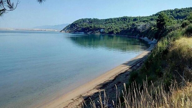 A calm lake with a sandy beach and a forested hillside in the background. - Adorable apartment with swimming pool and terrace (Ljubač)