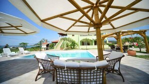 A poolside area with wicker chairs and a pergola providing shade. - Adorable apartment with swimming pool and terrace (Ljubač)
