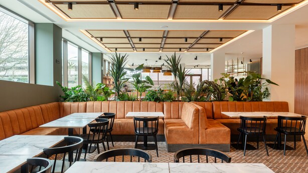 A modern restaurant with leather booths, marble tables, and black chairs. - Leonardo Hotel San Sebastián (San Sebastián)