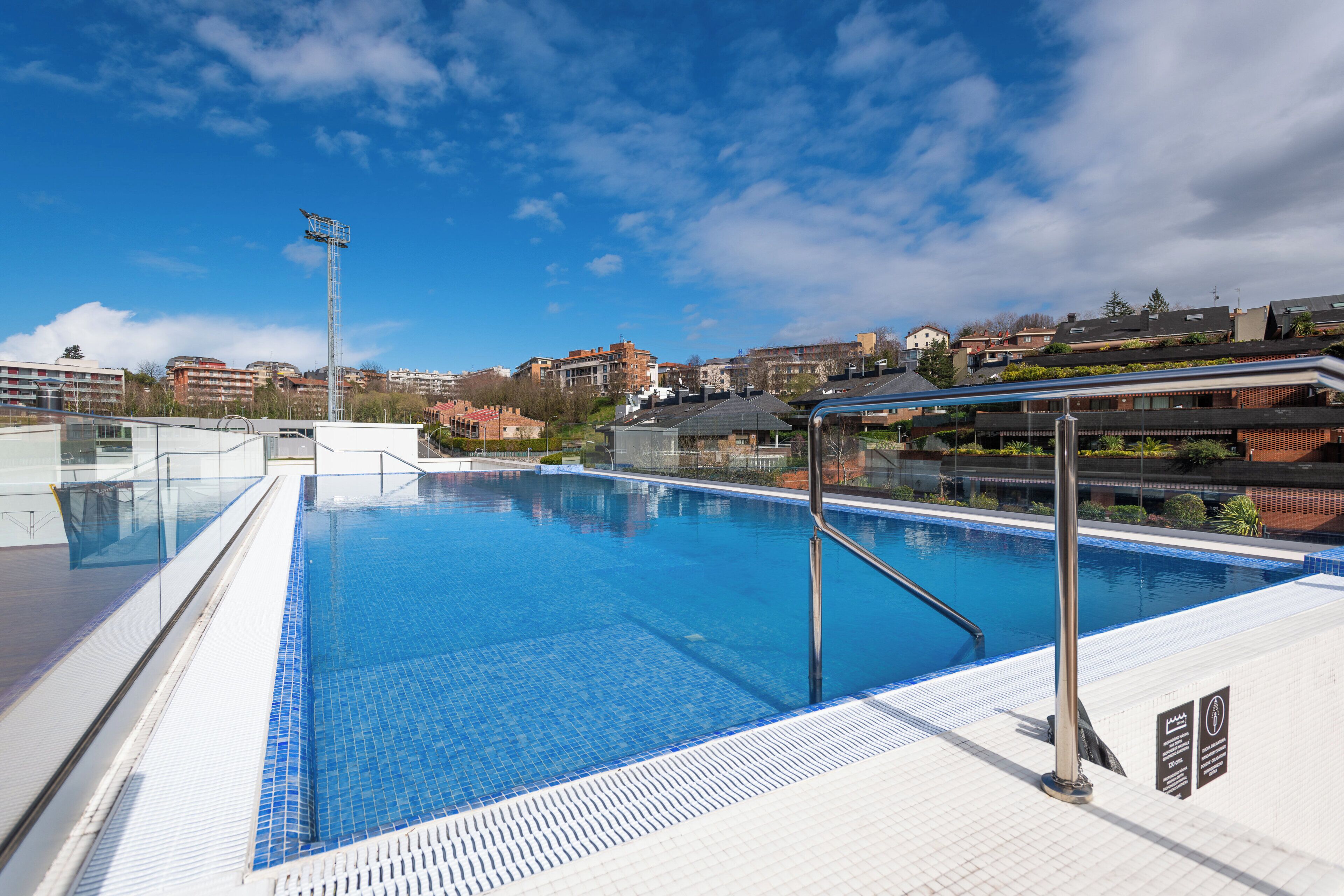 Una piscina al aire libre de temporada, sillones reclinables de piscina