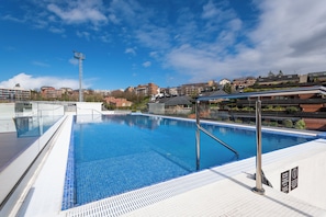 Una piscina al aire libre de temporada, sillones reclinables de piscina