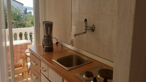 A kitchen with a sink, a coffee maker, and a stove.