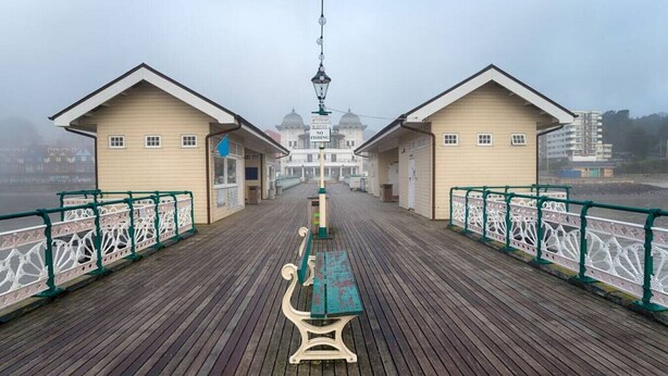 A wooden boardwalk with two small buildings, a bench, and a lamppost. - Luxe 2 Bed Duplex Apt w/Balcony, 3 Bathrooms, Free Parking (Penarth)