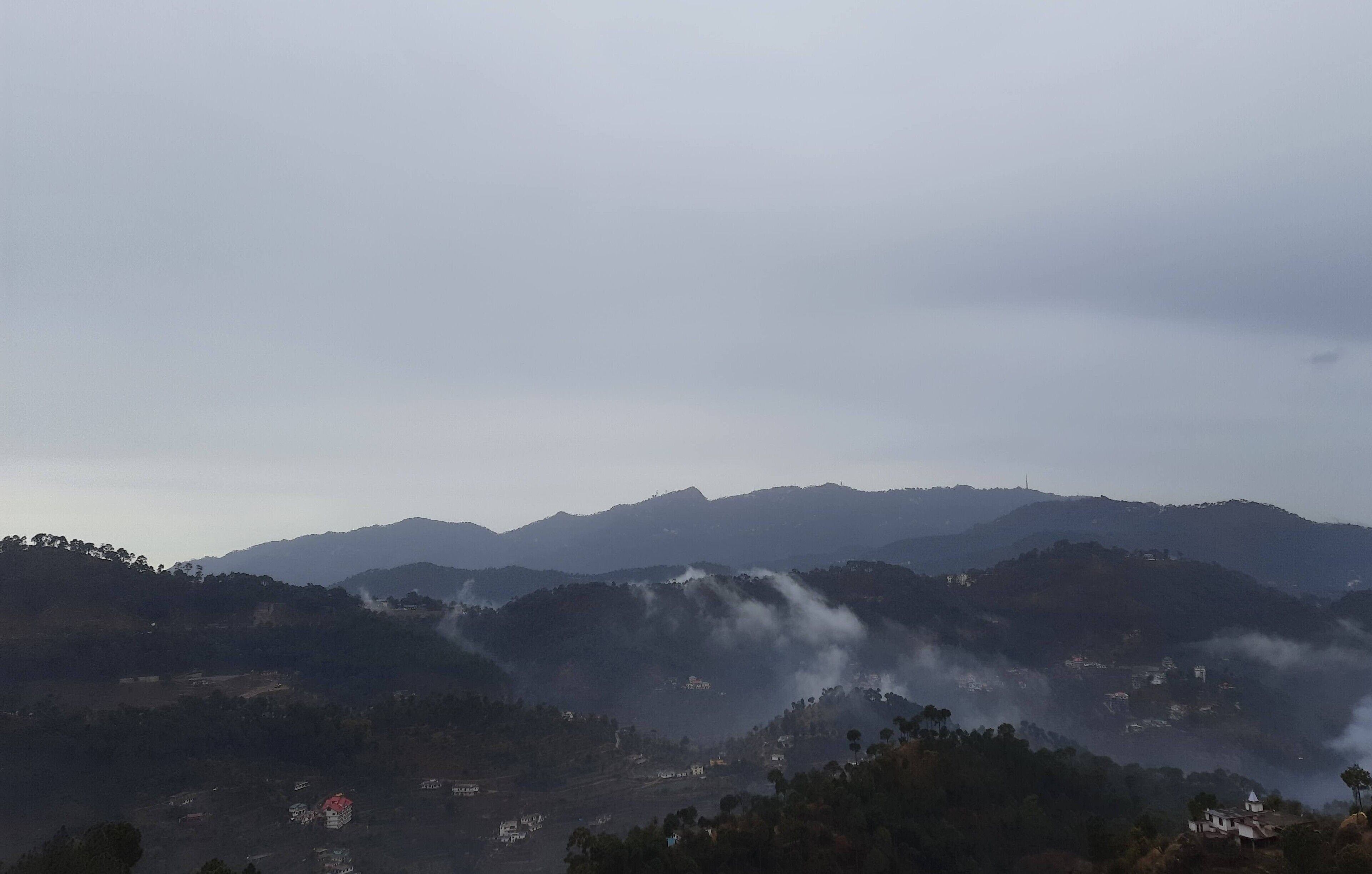 Un paysage montagneux avec un village niché au creux des collines.