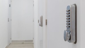 A modern hallway with a sleek, metallic door lock and a clean, white wall. - AYZ Silvela - Auto check-in property (Málaga)