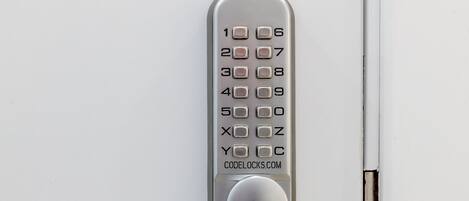 A numeric keypad lock on a white door.