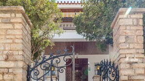 A stone gate with intricate metalwork leading to a building with a tiled roof and wooden doors. - AYZ Silvela - Auto check-in property (Málaga)