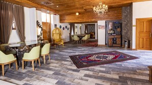 A spacious living area with a wooden ceiling, a dining table with chairs, and a large rug. -  WOO Town  (Antalya)