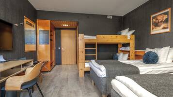 Habitación de hotel compacta con una cama litera, un escritorio con silla, un armario y un televisor.